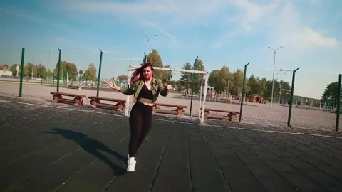 Dancing girl performing energetic dance on sports ground. Video stock 148473301