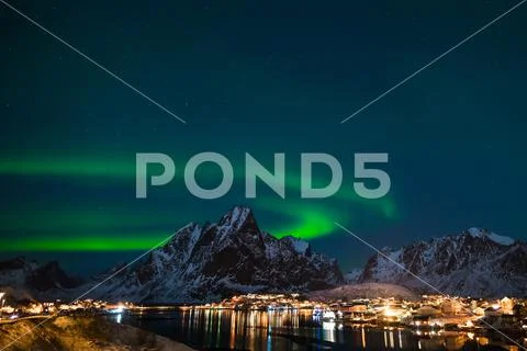 Dancing green polar lights over the village Reine on the Lofoten ...