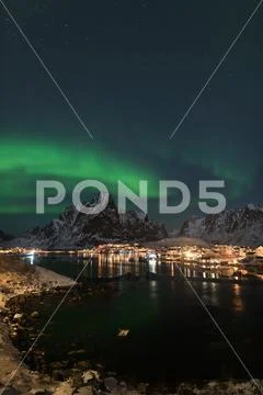 Dancing green polar lights over the village Reine on the Lofoten ...