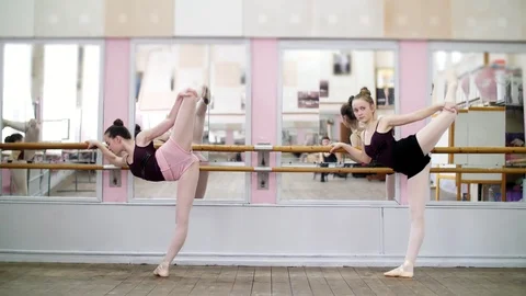In dancing hall, Young ballerinas in black leotards are stretching, standing Stock Footage 89145366