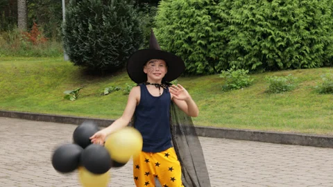 Dancing Halloween boy. Schoolboy having fun with orange and black balloons. Stock Footage 159133716