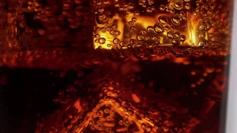 Dancing Ice cubes in a glass of soda – refreshing cold Cola on ice Stock Footage