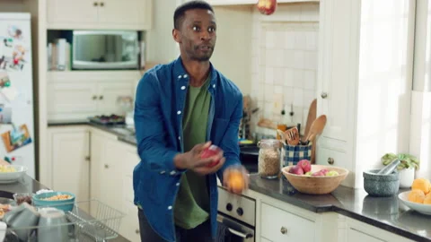 Dancing, juggle and black man in kitchen with energy for performance, humor and Stock Footage 335802110