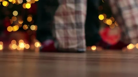 Dancing legs in Christmas socks and pajamas dance near Christmas tree golden Stock-Footage 224569247