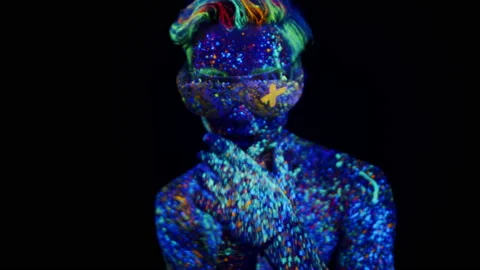 A dancing man in fluorescent paint and glasses with the x sign is actively Stock Footage 223510864