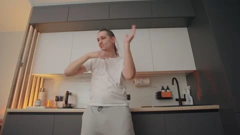 Dancing in a modern kitchen during evening light with creative moves and Stock Footage 307037313