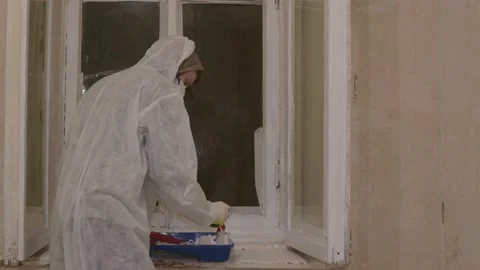 Dancing painter in protective suit paints toxic poisoning windows 스톡 동영상 148398106