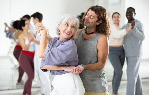 Dancing positive couples learning salsa Stock-Fotos