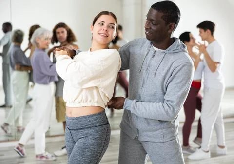 Dancing positive couples learning salsa Stock Photos