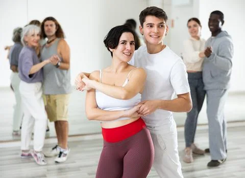 Dancing positive couples learning salsa Stock Photos