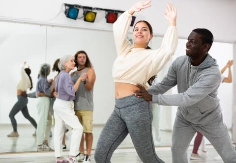 Dancing positive couples learning salsa Stock Photos
