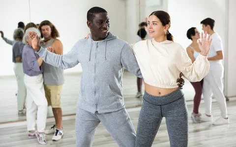Dancing positive couples learning salsa Stock Photos