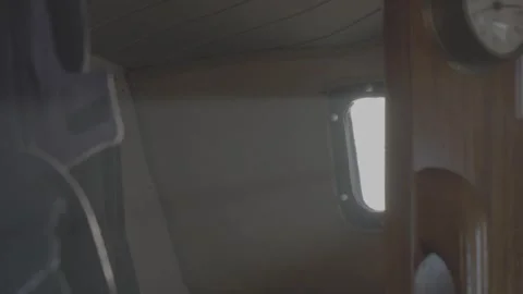 Dancing sunlight reflections from a boat porthole on cabin interior Stock Footage 330675641