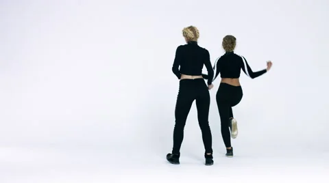 Dancing two girls on a white background in studio. 4K 30fps ProRes (HQ) Stock Footage 66909017