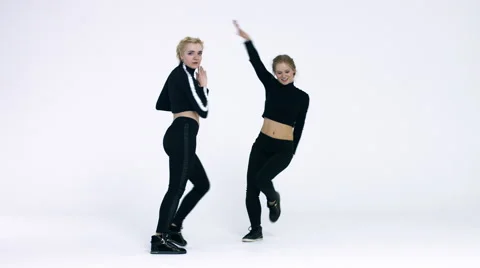 Dancing two girls on a white background in studio. 4K 30fps ProRes (HQ) Video stock 66909330
