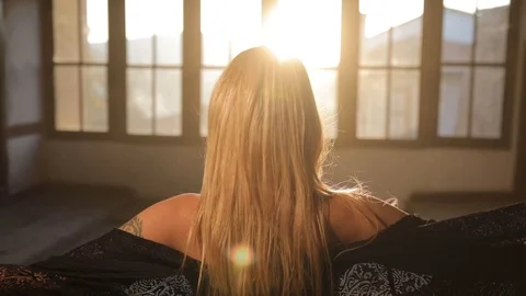 Dancing woman dancing in front of large windows as the sun goes down 库存影片 128661903