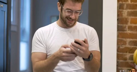 Dancing young man using mobile phone pumping arm in air celebrating success 스톡 동영상 82270968