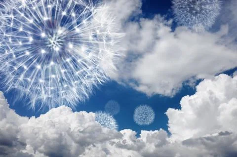 Dandelion against the blue sky in the clouds. Blowball fly in the wind and 写真素材