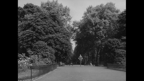 Dandy riding a penny-farthing bicycle in a park, UK 1959 Video stock 133383890