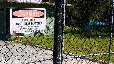 Danger asbestos warning sign on the gate of a utility site Stock Photos