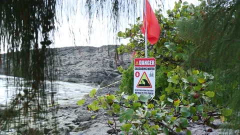 Danger cascading water sign with warning flag ocean safety 60fps 4k Stock Footage 154650103