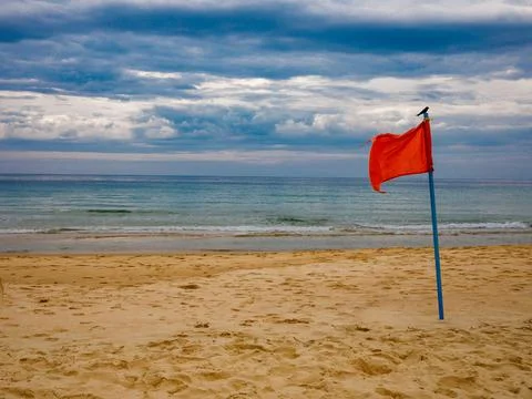 Danger concept background - severe storm warning flags on beach. Stock Photos