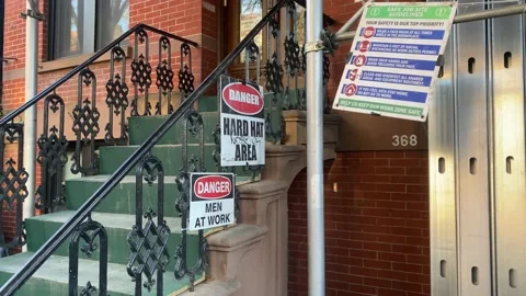 Danger Hard Hat Area sign and Danger Men At Work Sign on residential home i.. Stock Footage 228690302