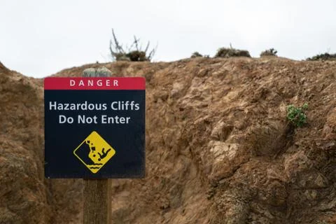 Danger hazardous cliffs do not enter with person falling sign leading up path Stock Photos