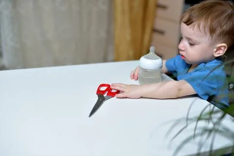 Danger in the home, sharp objects are dangerous for young children. little boy 库存照片