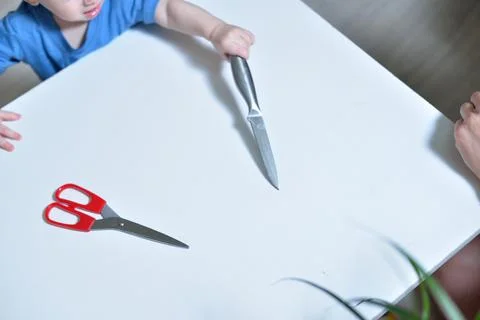 Danger in the home, sharp objects are dangerous for young children. little boy Stock Photos