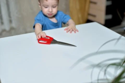 Danger in the home, sharp objects are dangerous for young children. little boy 库存照片
