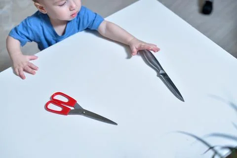 Danger in the home, sharp objects are dangerous for young children. little boy 库存照片