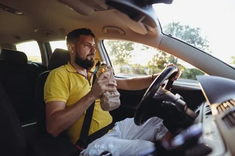 Danger on the Road. Man Drinking While Driving Stock Photos