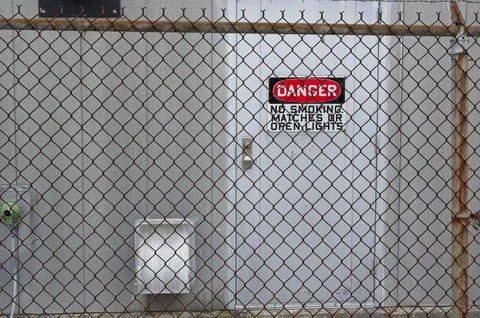 Danger sign through a chain link fence Stock Photos