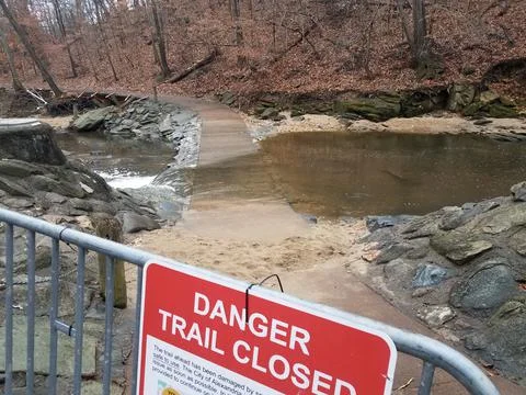 Danger trail closed sign with path and river flood Stock Photos