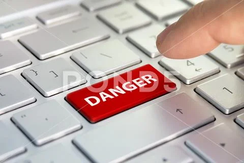 Danger word on computer keyboard button. Finger presses the color button on g Stock Photos