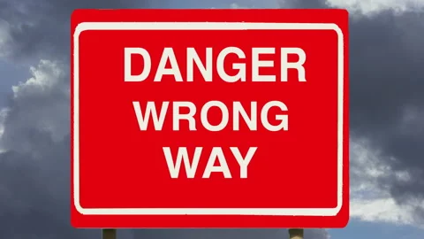 Danger Wrong Way directional road sign with time lapse dark clouds. Decisions. Stock Footage 143966983