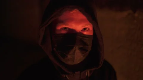 Dangerous aggressive sight of a young anonymous criminal in a hood and mask Stock Footage 144671359