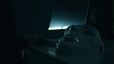 Dangerous anonymous hacker in hood typing a keyboard and using computer Stock Footage 93224660