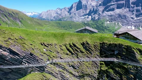 Dangerous bridge hanging from a cliff on top of a mountain Stock Footage 246983760
