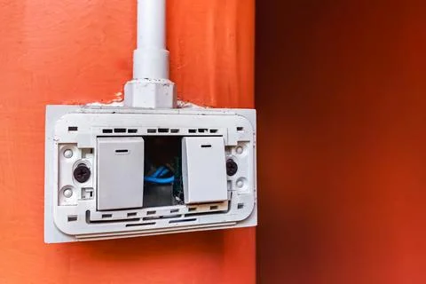Dangerous broken electricity outlet socket and light switch on wall hole. O.. Stock Photos