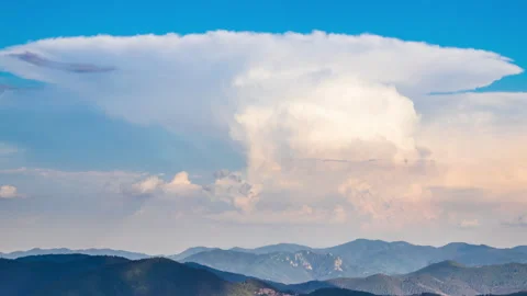 Dangerous clouds scatter across the sky from a explosion in the depths of the Stock Footage 230079770