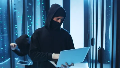 Dangerous computer hacker in hoodie programming virus code on laptop intended to Stock Footage 120695711