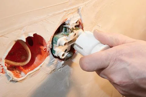 Dangerous connection of an electrical plug to a new socket without a decorative Stock Photos