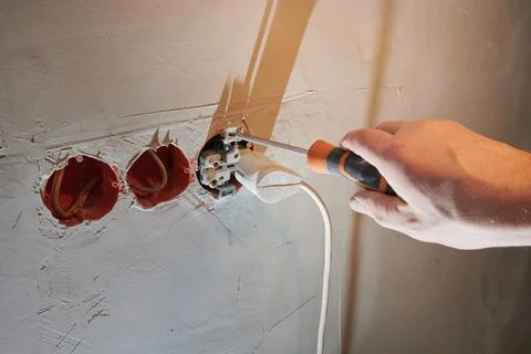 Dangerous connection of an electrical plug to a new socket without a decorative Stock Photos