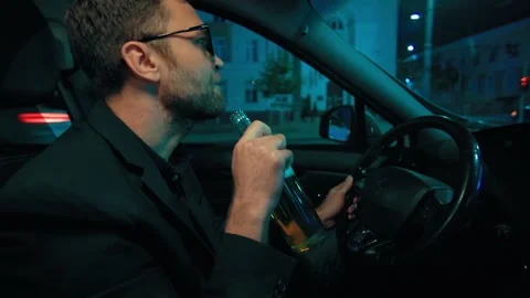 Dangerous driver drinking beer from bottle while operating car. Substance abuse Stock-Footage 346998587