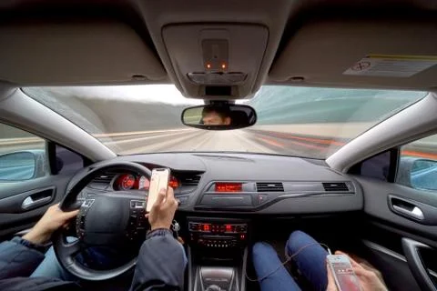 Dangerous driving while writing SMS text message Stock Photos