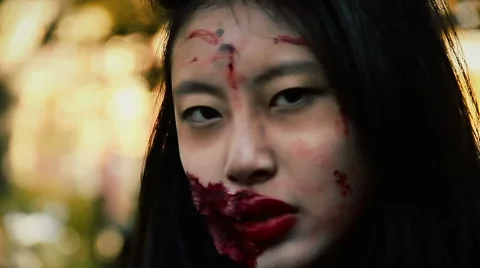 Dangerous female vampire with bloody injury on face looking fiercely at victim Stock Footage 59082725