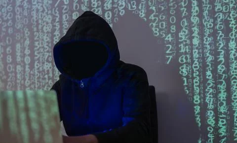 Dangerous hooded hacker breaks into data servers and infects their system w.. Foto stock