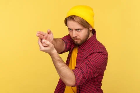 Dangerous hooligan hipster guy in beanie hat and checkered shirt pointing fin Stock Photos